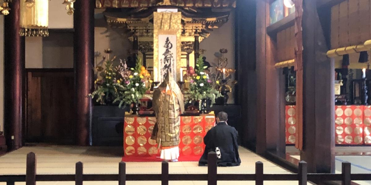 祖師執筆の名号(南無阿弥陀仏の掛け軸)を前に祈念される御導師